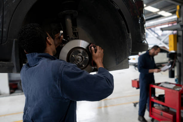 african american mechanic changing a flat tire at an auto repair shop